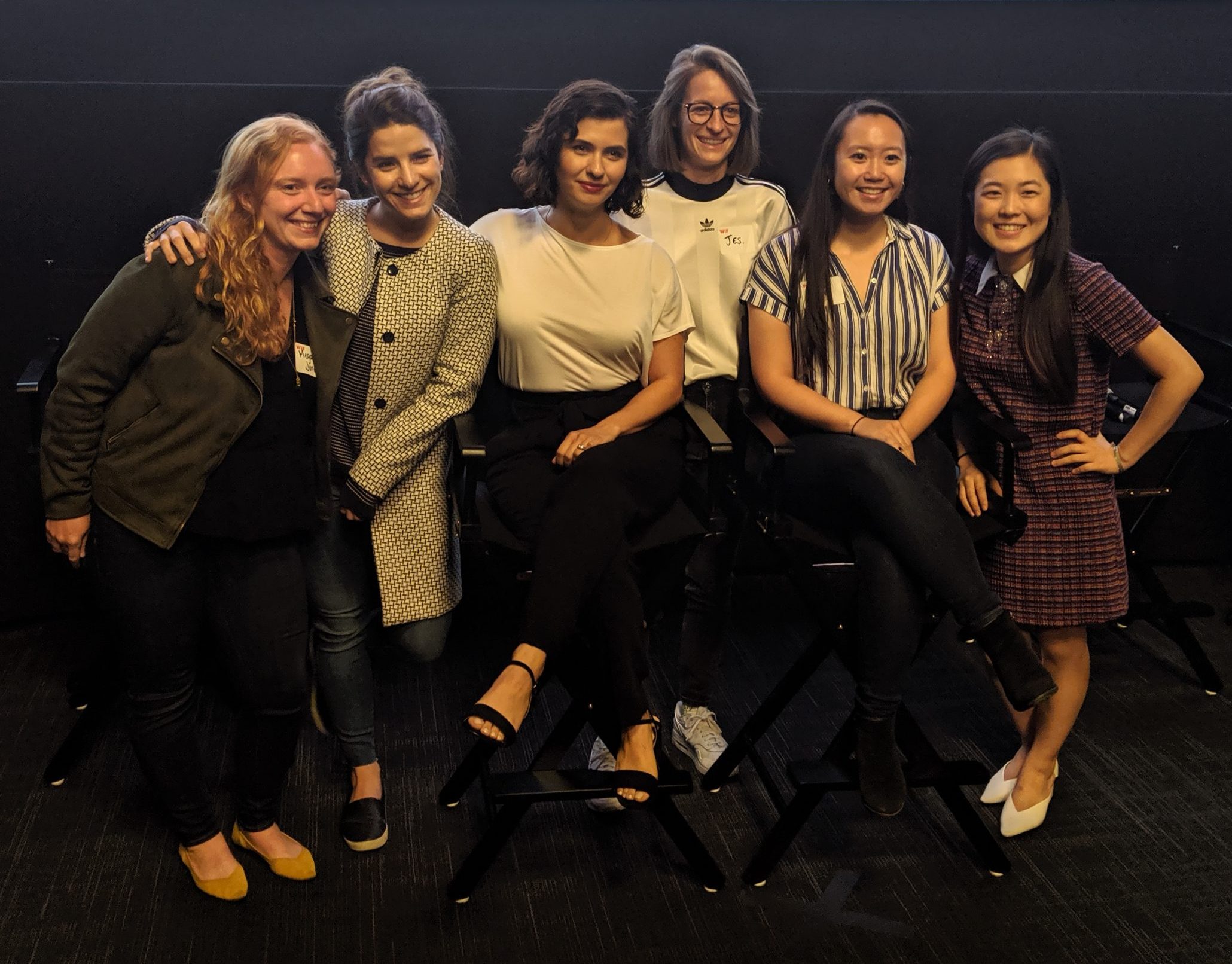 http://A%20group%20of%20young%20women,%20some%20in%20director's%20chairs,%20smiling%20with%20their%20arms%20around%20each%20other's%20shoulders.