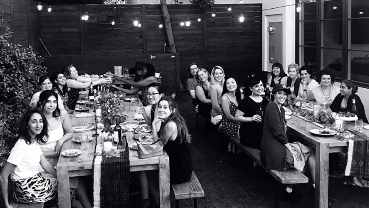 http://Women%20sitting%20at%20two%20dining%20tables